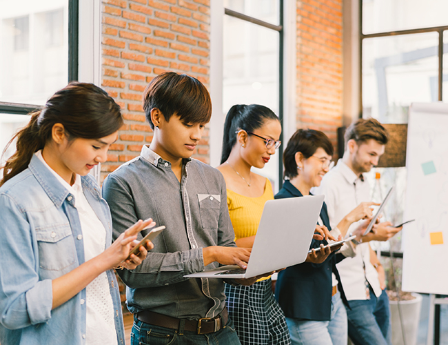 students standing in office meeting with board beside them