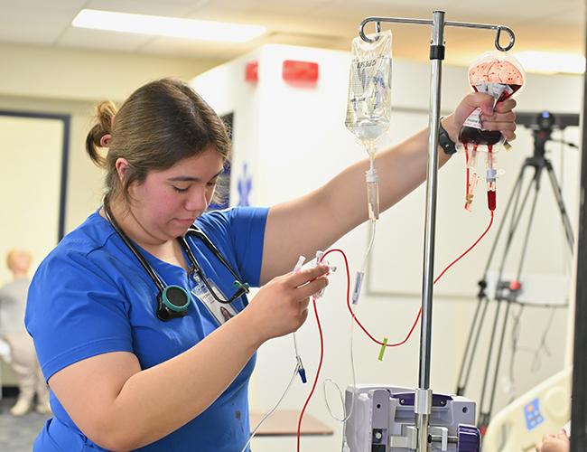 nursing student hanging blood